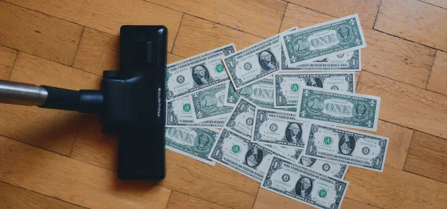 a pile of money sitting on top of a wooden floor by rc.xyz NFT gallery courtesy of Unsplash.